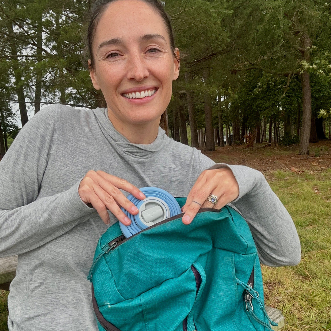 A woman packs up a HYDAWAY collapsible water bottle