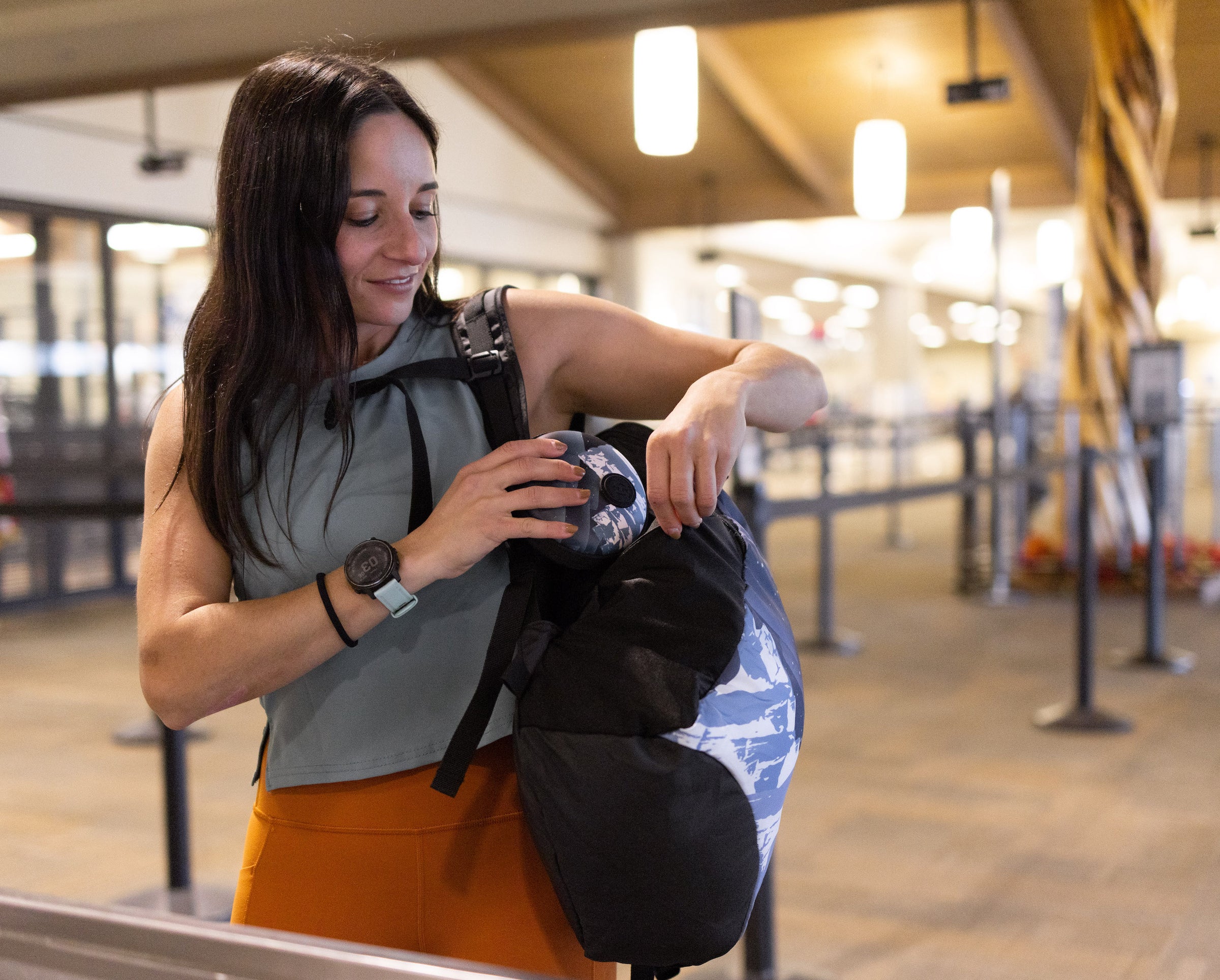 A woman packs up her HYDAWAY collapsible water bottle into a travel case before boarding her flight at TSA security checkpoint